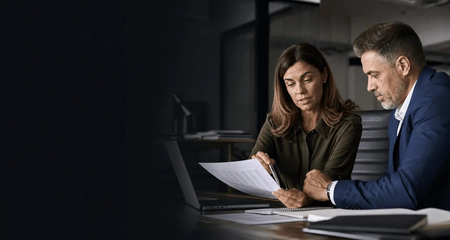 Two finance professionals reviewing a recurring client agreement and billing schedule